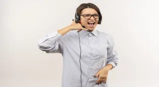 A woman wearing a headset and making a phone call gesture