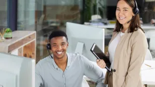 Two bank employees wearing professional wireless headsets with noise-cancelling microphones, working at a banking call center to provide clear customer service.