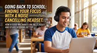 Student wearing a noise-canceling headset with mic while studying on a laptop in a busy library.