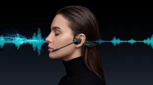 Side profile of a woman wearing a professional open ear headphone with mic, showing the bone conduction technology and an integrated microphone boom against a dark background with blue sound waves.