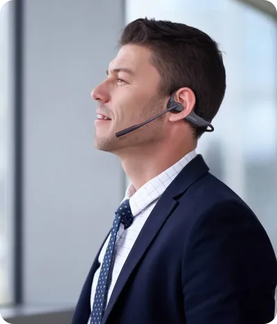 man wearing openear headphone with mic at office