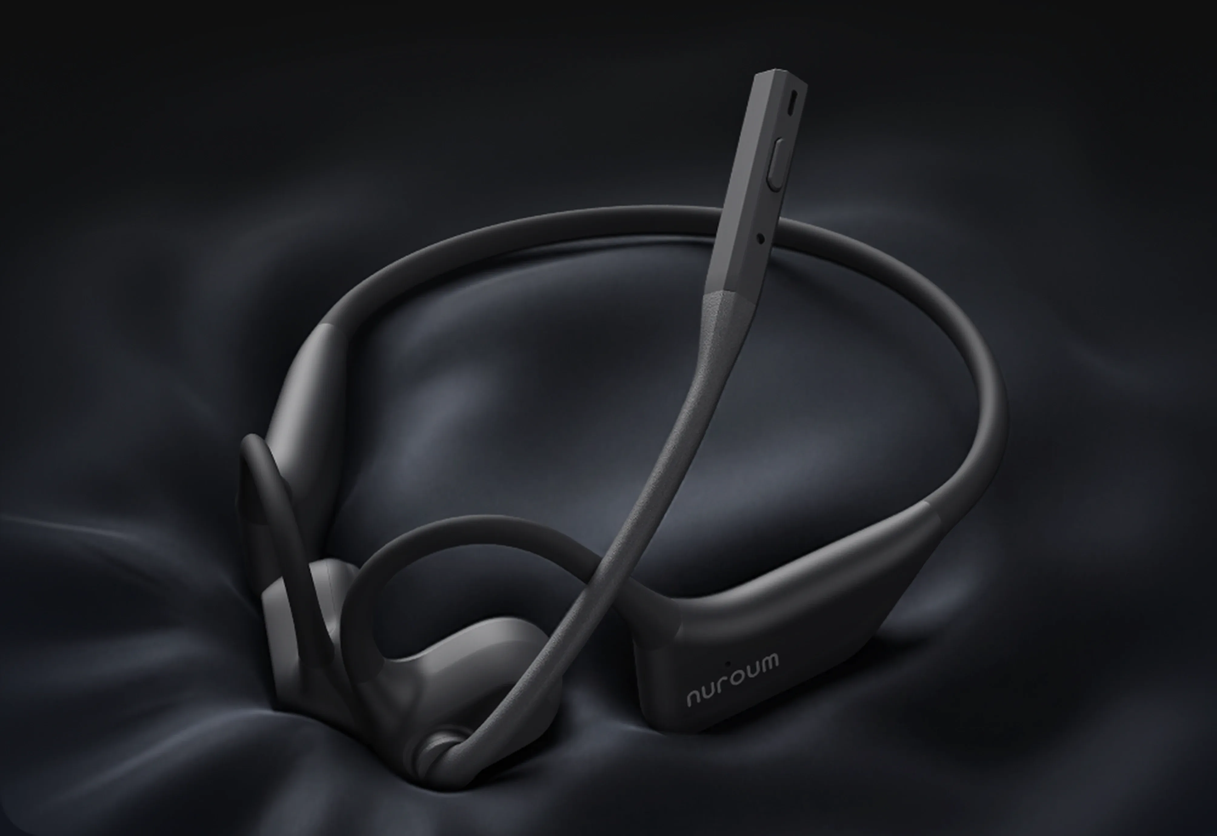Nuroum open-ear headset resting on smooth black silk fabric, showcasing its sleek matte finish and ergonomic build.