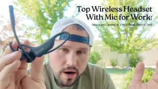 Man holding up a black Nuroum open-ear headset with a boom microphone for demonstration outdoors.